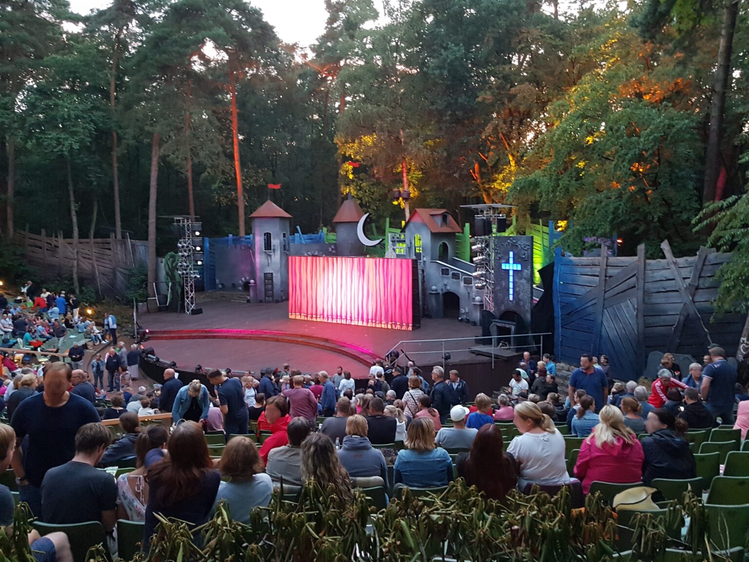 Auf der Emsländischen Freilichtbühne in Meppen warten farbig beleuchtete Kulissen auf das Stück The Addams Family.