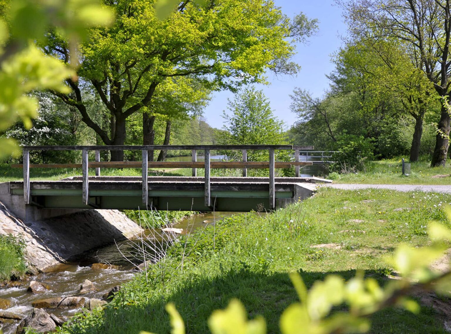 Familienhotel Gut Landegge im Emsland: Umgebung Meppen, Holzbrücke bei schönem Wetter mit Bach