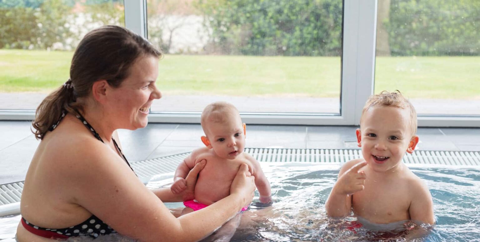Familienhotel Gut Landegge im Emsland: Frau mit Baby und Kleinkind im Schwimmbad